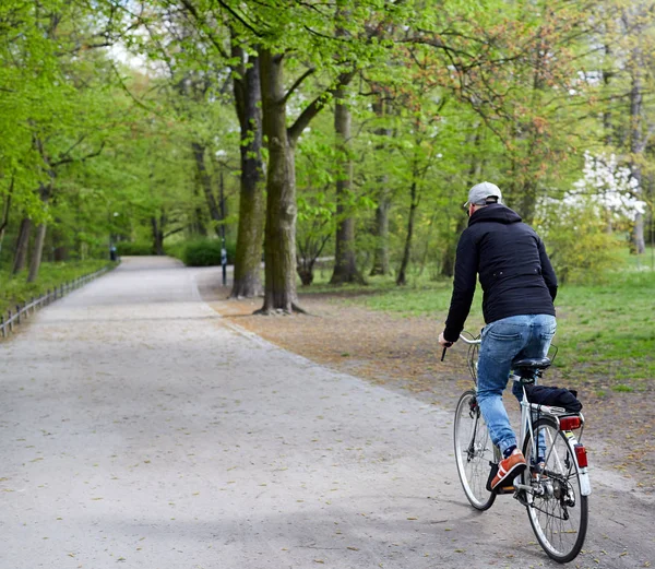 Νεαρός άνδρας ιππασία με το ποδήλατό του στο πάρκο — Φωτογραφία Αρχείου