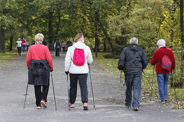 WROCLAW, POLONIA - 15 DE OCTUBRE DE 2017: La gente en el curso de fitness nordic walking competition in the city park — Foto de Stock