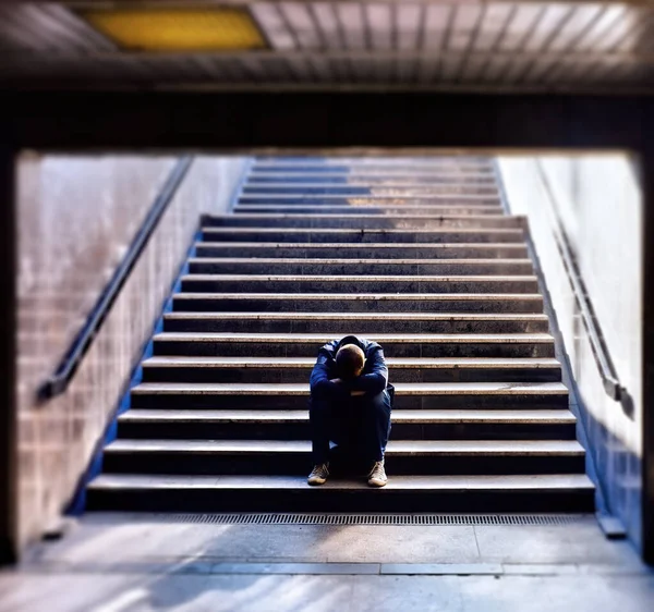 Lonely man sitting on the stairs — Stock Photo, Image