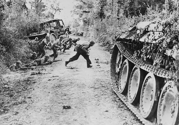 Soldados americanos correm através de uma estrada de terra perto de St. Lo, na Normandia, França, em 25 de julho de 1944 . — Fotografia de Stock