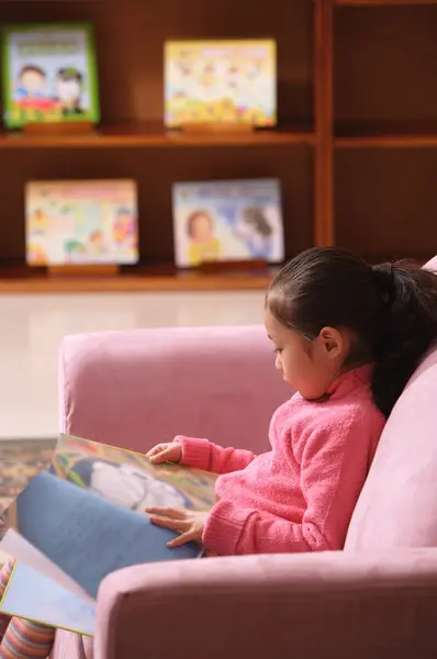 Fille avec livre assis sur canapé — Photo