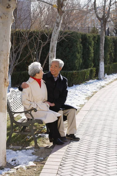 Elderly couple sitting on park bench — Stock Photo, Image