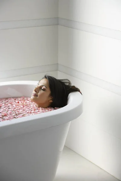 Nainen makaa kylpyammeessa — kuvapankkivalokuva