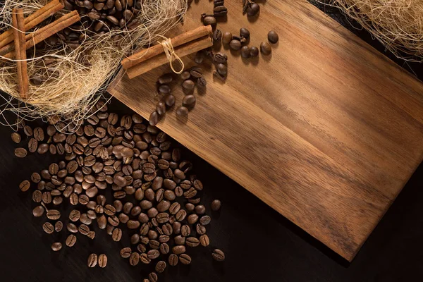 Granos de café tostados negros y canela. Sobre un fondo de madera. Vista superior y marco para inscripciones . — Foto de Stock