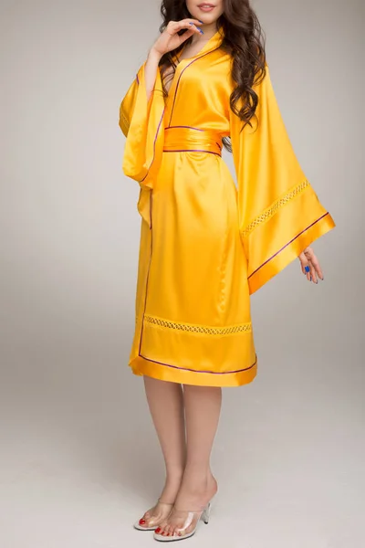Girl in yellow silk robe, gray background