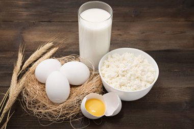 Süt ürünleri ahşap masa üzerinde. Süzme peynir, süt, yumurta ve yumurta sarısı. Kopya ile Üstten Görünüm 