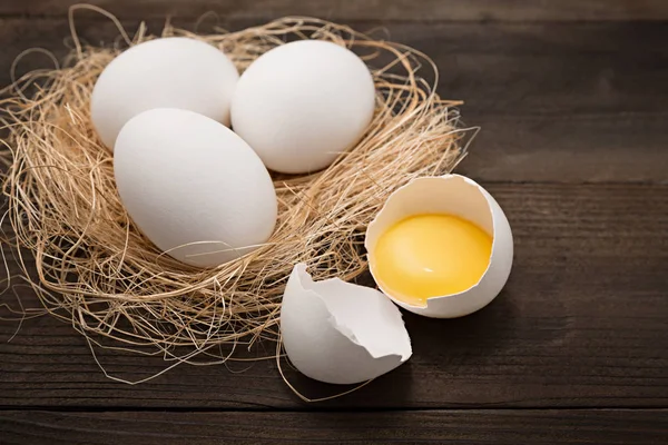A tojás összetört, a tojássárgája, a fából készült háttér — Stock Fotó