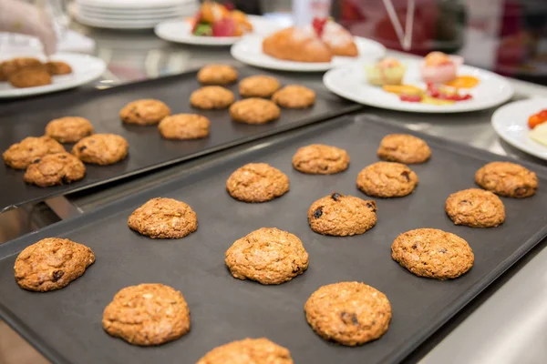 Hot delicious oatmeal cookies on baking tray from oven — Stock Photo, Image