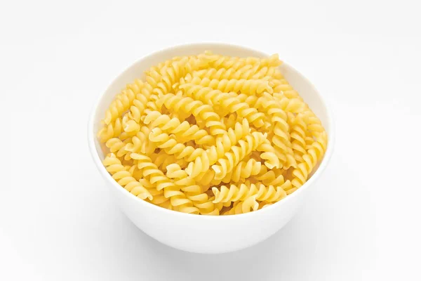 Pasta spiral or fusilli close-up in white bowl,  white background — Stock Photo, Image