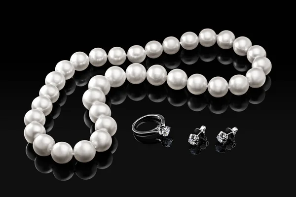 Conjunto de lujo collar de perlas blancas y joyas con diamantes en anillo y pendientes sobre un fondo negro con reflejo brillante y plantilla en blanco para su diseño o copiar el espacio de su texto — Foto de Stock