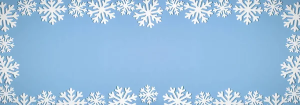 Kompozycja świąteczna z panoramicznym brzegiem białych ozdobnych płatków śniegu na niebieskim tle. Płaskie ułożenie, widok z góry, przestrzeń do kopiowania — Zdjęcie stockowe