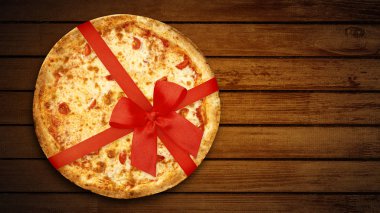 Kırmızı kurdeleli Holiday Pizza margherita kırsal koyu kahverengi arka planda hediye tasarımı için. Üst Manzara. Düz yatıyordu