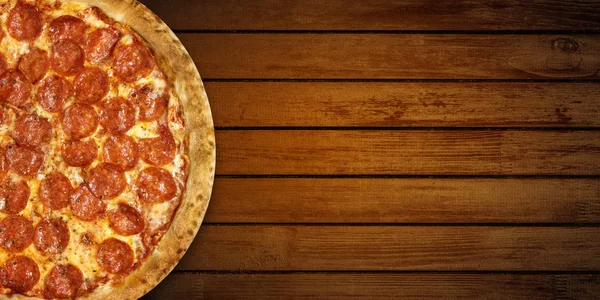 Pizza na drewnianym stole. Widok z góry gorącej pizzy pepperoni zbliżenie z serem mozzarella. Baner płaski z przestrzenią do kopiowania — Zdjęcie stockowe