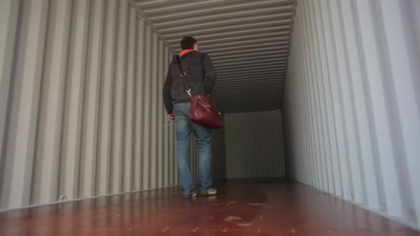 Внутри пустой грузовой контейнер. Человек проверяет контейнер — стоковое видео