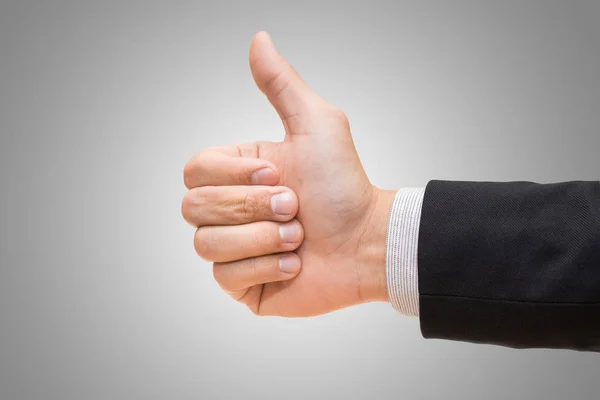 Businessman hand giving thumbs up on over gray background — Stock Photo, Image