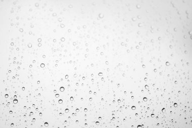 Window glass with drops of rain. Atmospheric light monochrome background with raindrops in bokeh clipart