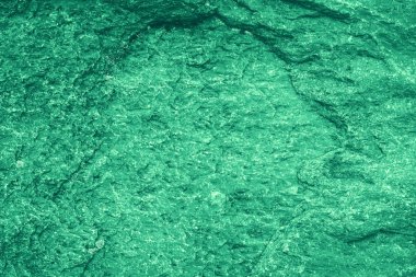 Vintage green background. Rough painted wall of emerald color. Imperfect plane of virid colored. Uneven old decorative toned backdrop of green tint. 