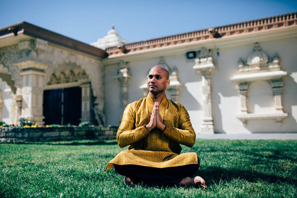 Handsom Indian Man Greeting Namaste in Gold Kurta at the Temple