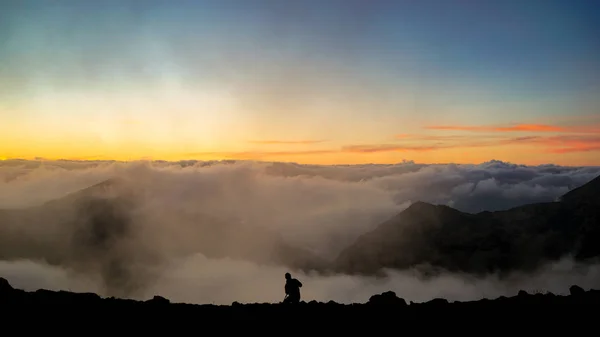 Le photographe prenant des photos sur la montagne avec des nuages Dur — Photo