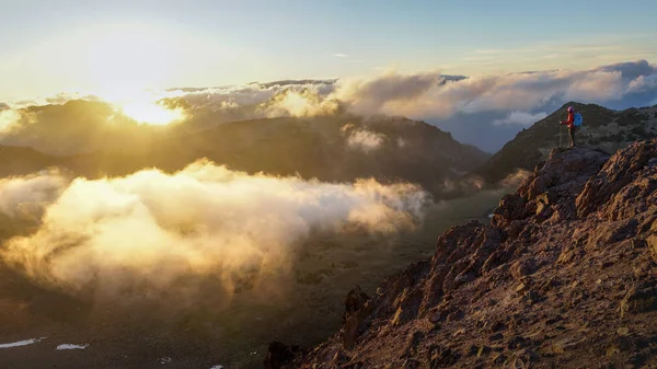 Une personne debout sur la montagne avec des nuages au coucher du soleil / Sunr — Photo