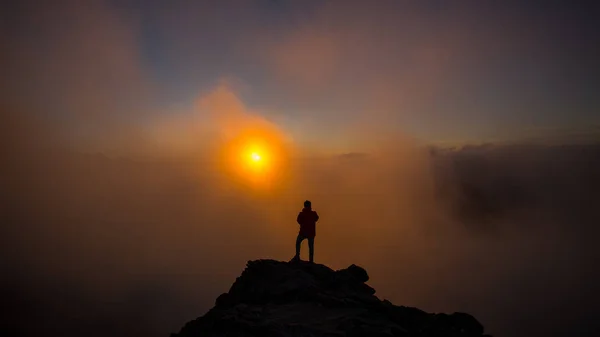 O fotógrafo tirando fotos na montanha com nuvens Dur — Fotografia de Stock