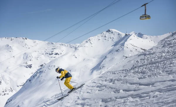 Yellow ski rider with mountain cable car