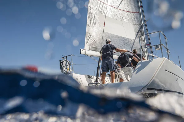 Aft of sailing boat with skipper from underwater view — Stock Photo, Image