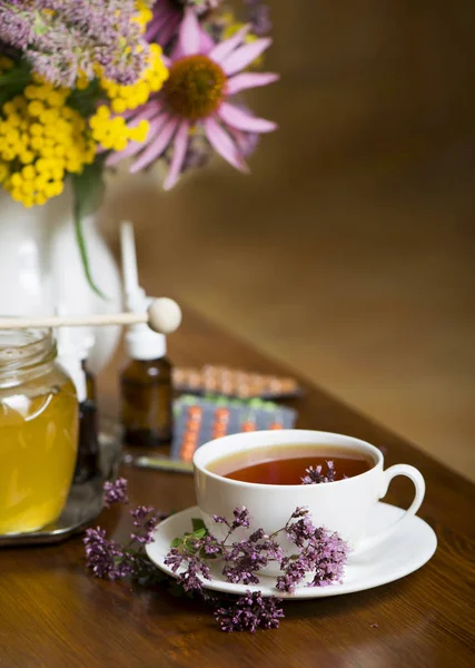 Bodegón de hierbas medicinales, miel, té de hierbas y medicinas —  Fotos de Stock