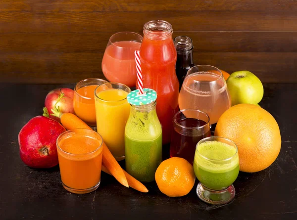Sucos de frutas e vegetais em um fundo escuro — Fotografia de Stock
