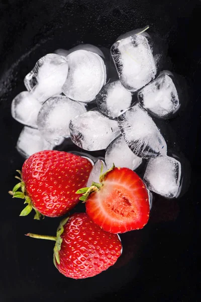 Cubos de hielo con fresas en negro —  Fotos de Stock