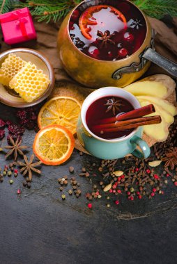 Sıcak şarap, mavi çam ağacı dalı ve ahşap arka planda baharatlar.