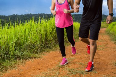 Asyalı çiftler, güneşli havada ormanda yolda koşuyorlardı.