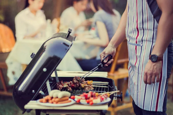 Asian men are cooking for a group of friends to eat barbecue