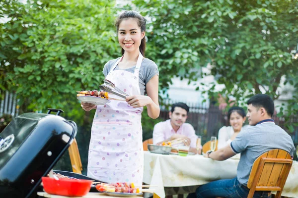 Asyalı kadınlar bir arkadaş yemek için bir Barbekü yemek vardır