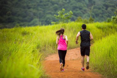 Çiftler doğada koşuyor.