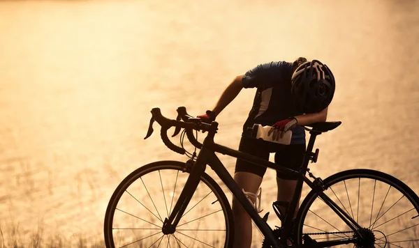 Mujer bicicleta estática Ella se sentía cansada y relajante bebida en el río — Foto de Stock