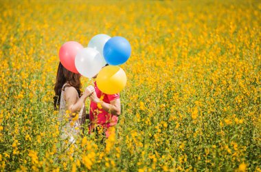 Çift Bahçe sarı çiçekler öpüşme. Sevgililer günü balonları gözlerle kalkan yardımcı olur