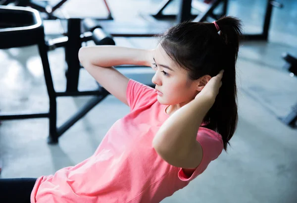 Asiatische Frau sitzen bis auf die Turnhalle sie fühlt sich müde — Stockfoto