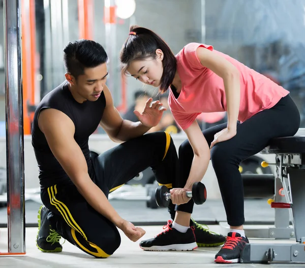 Trainer-Männer lehren asiatische Frauen, eine Hantel zu heben. in der — Stockfoto