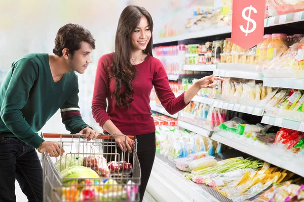 Çiftler süpermarkette yiyecek seçiyorlar.