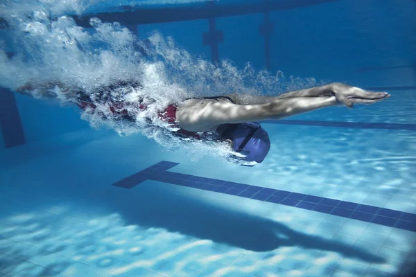 Nadador saltar da plataforma saltando uma piscina. ph subaquático — Fotografia de Stock