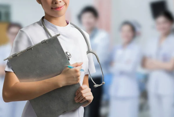 Une infirmière asiatique tenant un dossier en acier. Pour sauver la situation du patient — Photo