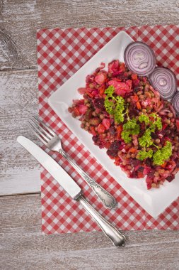 Rus pancar salatası salata beyaz plaka üzerinde damalı peçete ahşap arka plan üzerinde