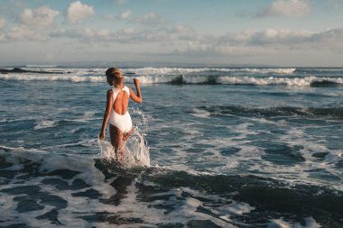 woman walking along coastline 