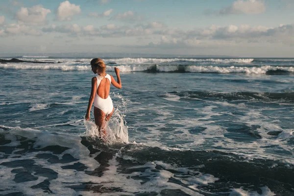 Woman walking along coastline — Φωτογραφία Αρχείου