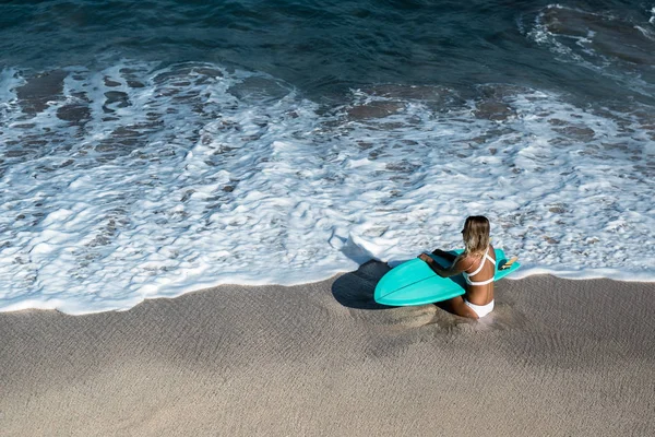 Femme avec planche de surf à la plage — Photo