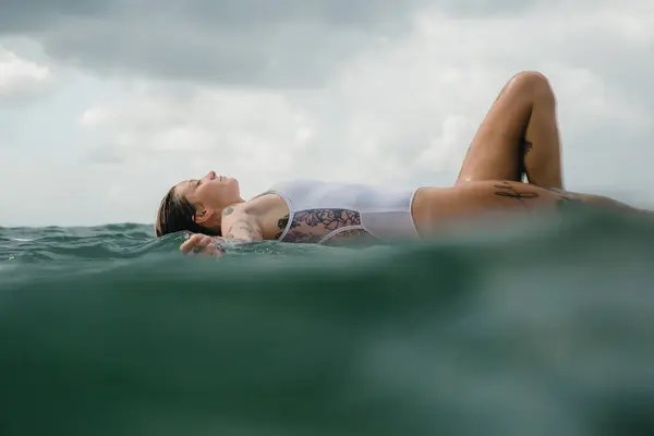 Mujer acostada sobre tabla de surf —  Fotos de Stock
