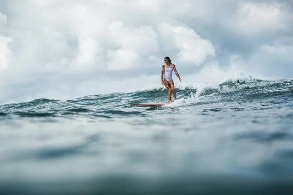 Female surfer catching wave — Stock Photo, Image