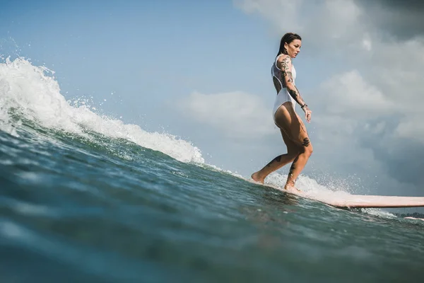 Kvinnliga surfare fånga våg — Stockfoto