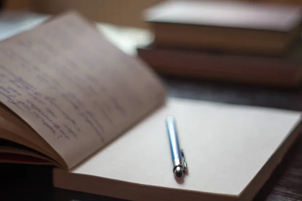 Bloc-notes ouvert avec notes manuscrites avec des livres de stylo bleu dans le b — Photo